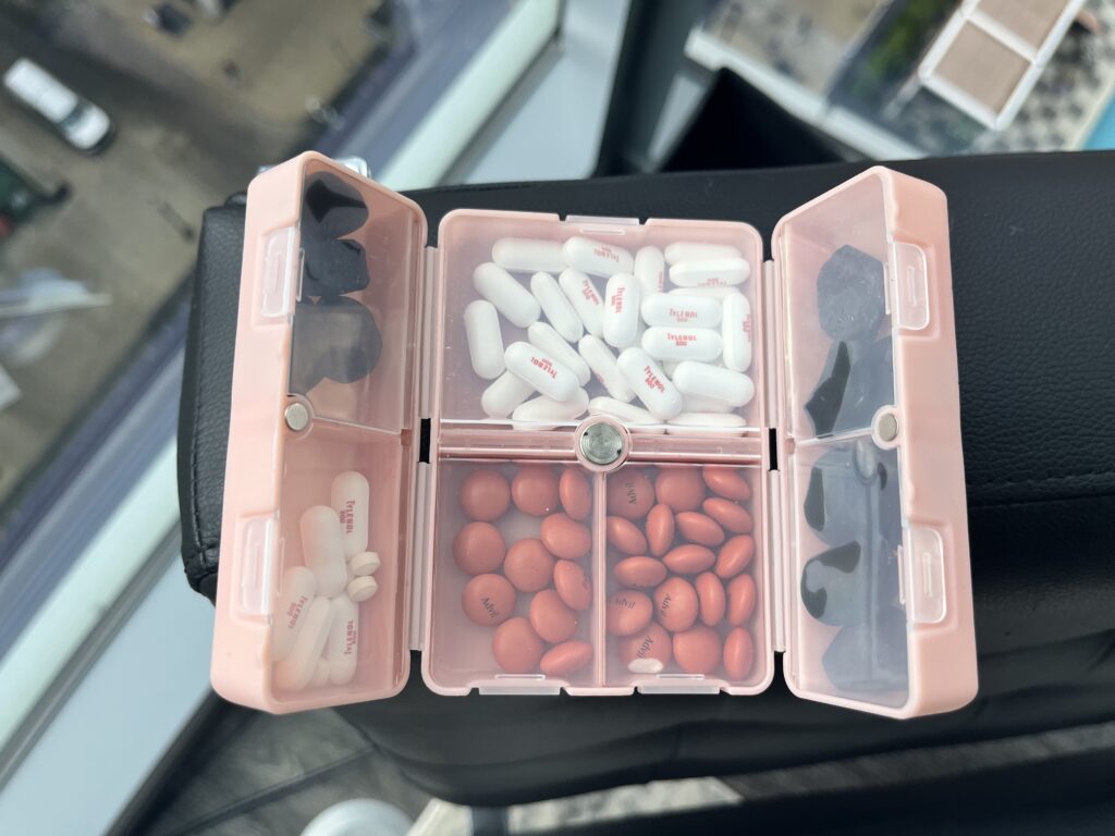 Pink pill case with Advil, Tylenol, Melatonin