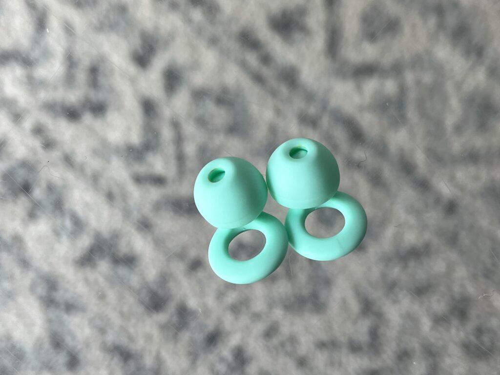 Blue green ear plugs on an acrylic table