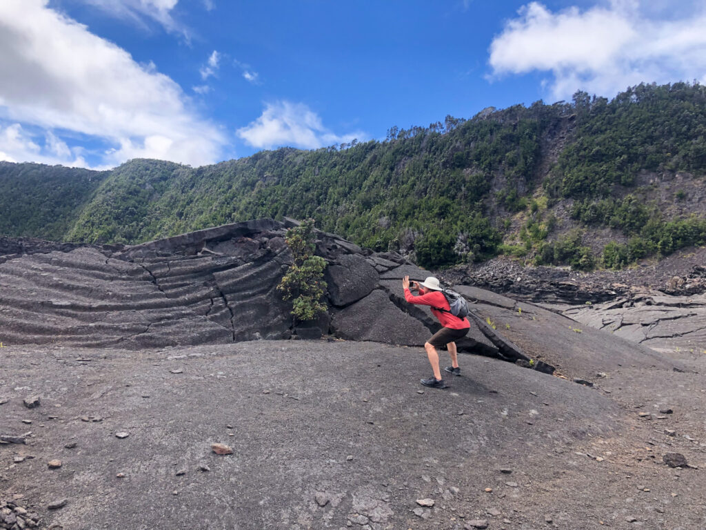 Man squatting on the crater floor of Hawai'i Volcanoes National Park