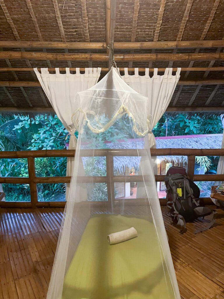 A mattress on the floor with mosquito netting protecting it