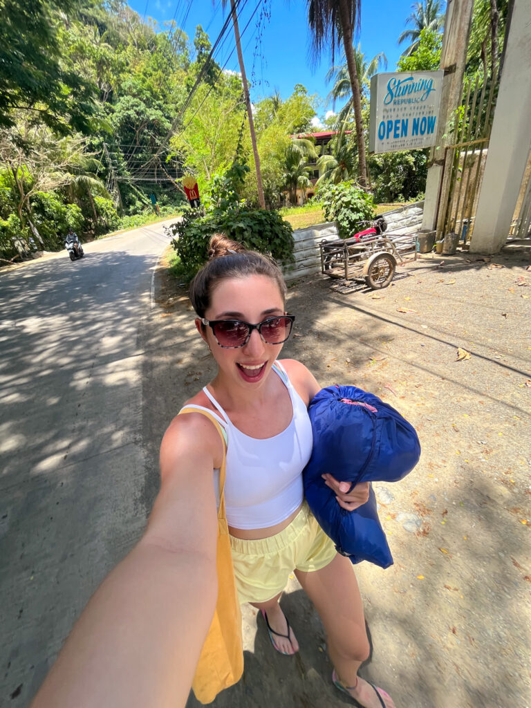 Selfie of woman walking in El Nido with a laundry bag