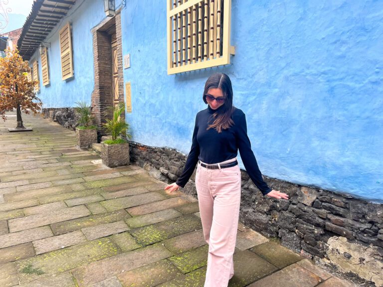 Girl on a street in front of a blue building