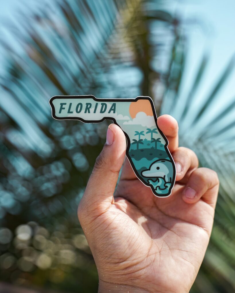 Hand Holding Up a Florida Sticker (Boca Chita Key (Courtesy of Unsplash)