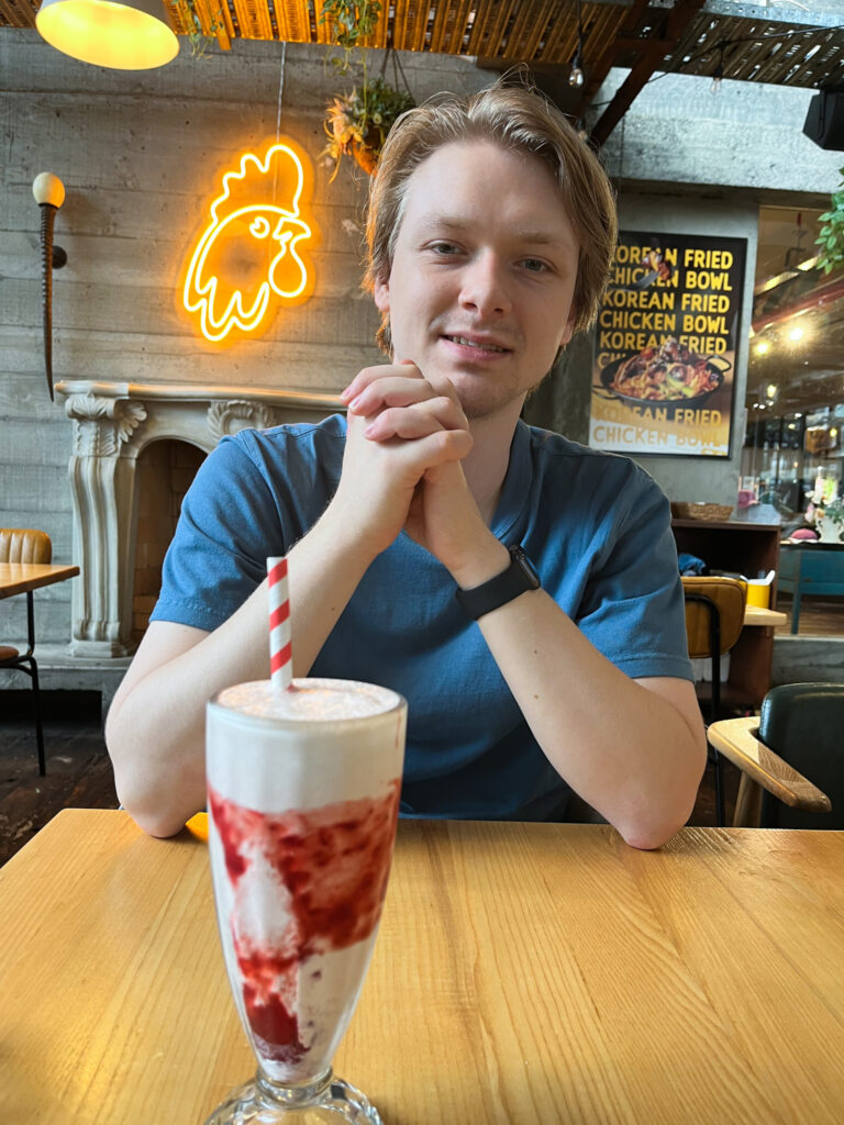 Young man drinking a strawberry milkshake